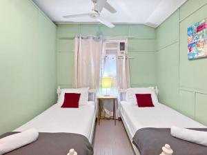 two twin beds in a room with a window at The Barracks Arcadia 2 in Arcadia