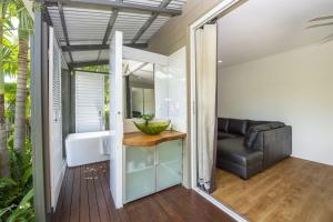 a bathroom with a tub and a sink and a couch at Whispering Palms in Nelly Bay