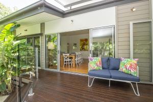 a porch with a blue couch on a house at Whispering Palms in Nelly Bay +14 photos