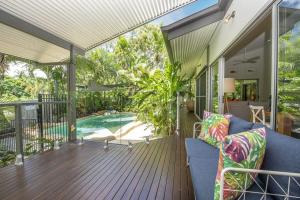 an open deck with a blue couch on a house at Whispering Palms in Nelly Bay