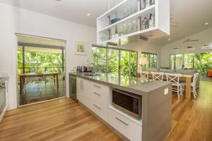 a kitchen with a counter and a dining room at Whispering Palms in Nelly Bay