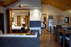 a living room with a bed and a living room with a television at Pure Magnetic Villa 3 in Nelly Bay