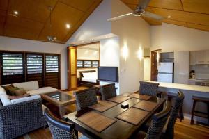 a living room with a table and chairs and a kitchen at Pure Magnetic Villa 3 in Nelly Bay