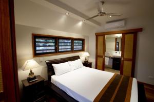 a bedroom with a white bed and a bathroom at Pure Magnetic Villa 3 in Nelly Bay +13 photos