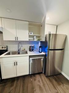 eine Küche mit weißen Schränken und einem Edelstahlkühlschrank in der Unterkunft Niagara Falls 2 Bedrooms 1 and half washroom Luxury Basement Apartment in Thorold