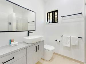 a white bathroom with a sink and a toilet at Kadani in Picnic Bay +17 photos