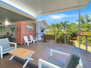 a patio with a table and chairs on a deck at Kadani in Picnic Bay