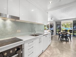 a kitchen with white cabinets and a dining room with a table at Island View Apt 1 in Arcadia +18 photos