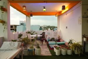 a balcony with potted plants and a table and chairs at Hostel Mama in Udaipur