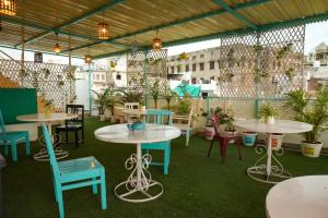 a patio with tables and chairs and plants at Hostel Mama in Udaipur
