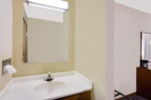 a bathroom with a sink and a mirror at Super 8 by Wyndham Macomb in Macomb +57 photos