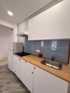 a kitchen with white cabinets and a sink at La casa del Borgo in Cetraro