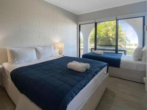 a bedroom with two beds and a large window at Beachside Palms Unit 3 in Nelly Bay +7 photos
