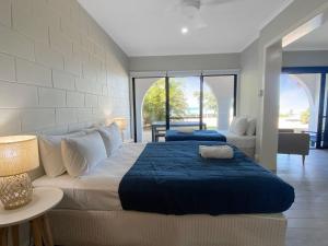 a bedroom with two beds and a living room at Beachside Palms Unit 3 in Nelly Bay