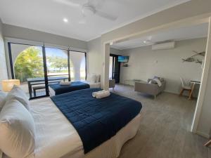 a bedroom with two beds and a living room at Beachside Palms Unit 3 in Nelly Bay