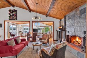 a living room with a red couch and a fireplace at Spa & Waterfront - Chalet le Colibri in Saint-Rémi-dʼAmherst