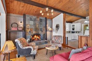 a living room with a fireplace and two chairs at Spa & Waterfront - Chalet le Colibri in Saint-Rémi-dʼAmherst +73 photos