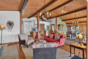 a living room with a red couch and chairs at Spa & Waterfront - Chalet le Colibri in Saint-Rémi-dʼAmherst