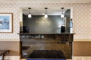 a bar in a restaurant with a sign on the wall at Baymont by Wyndham Janesville in Janesville +36 photos
