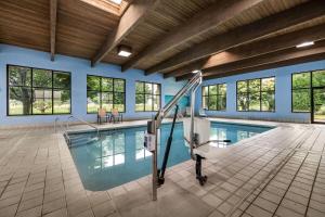 an indoor swimming pool with a slide in a building at Baymont by Wyndham Janesville in Janesville