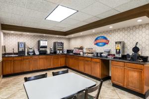 a bar with a table and chairs in a room at Baymont by Wyndham Janesville in Janesville