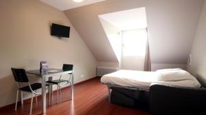 1 dormitorio con 1 cama, mesa y sillas en Aux Balcons du Sancy, en Picherande