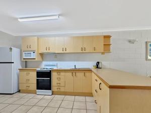 a kitchen with wooden cabinets and a white refrigerator at Arcadia Palms 2 in Arcadia
