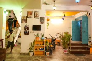 a man standing on a staircase in a room with plants at Hostel Mama in Udaipur