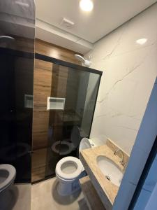 a bathroom with a toilet and a sink and a shower at Hotel New City in Guarulhos