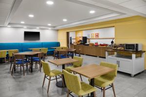 a cafeteria with tables and chairs and a kitchen at Hampton Inn Janesville in Janesville