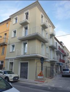 a tall building with cars parked in front of it at AL 54 Accommodation - Premium in San Benedetto del Tronto