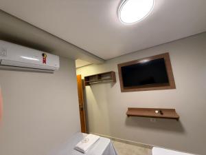 a bathroom with a flat screen tv on the wall at Hotel New City in Guarulhos