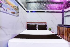 a bedroom with a white bed in a room at Hotel Gaurav in Ahār