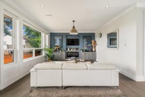 a living room with a white couch and a kitchen at 5-Star Luxury and comfortable home in New Westminster