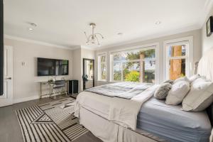 a bedroom with a large bed and a tv at 5-Star Luxury and comfortable home in New Westminster