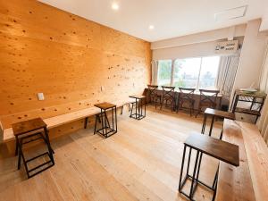 a room with wooden walls and tables and chairs at ArtBar & GuestHouse ennova in Atami