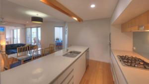 a kitchen with a sink and a stove top oven at Maggies Beachfront Apartment 6 in Horseshoe Bay +14 photos