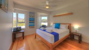 a bedroom with a large bed with blue pillows at Maggies Beachfront Apartment 6 in Horseshoe Bay