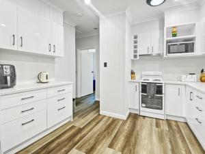 a white kitchen with wooden floors and white cabinets at Magnetic Reef Unit 2 in Arcadia