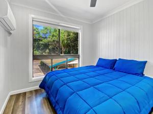 a bedroom with a large blue bed and a window at Magnetic Reef Unit 2 in Arcadia +12 photos
