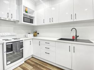 a white kitchen with white cabinets and a sink at Magnetic Reef Unit 2 in Arcadia