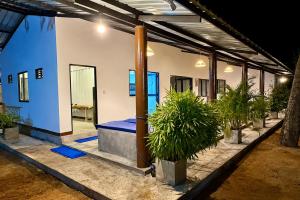 a room with potted plants in front of a house at Wave Hostels Arugam Bay - With Swimming Pool in Arugam Bay