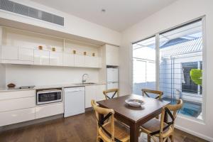 a kitchen with a table and chairs and a window at Reflections Topaz Villa 3 in Picnic Bay