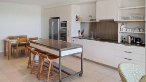 a kitchen with a table and some chairs in it at Blue on Blue Apartment 932 in Nelly Bay