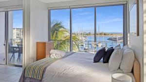 a bedroom with a bed with a view of the ocean at Blue on Blue Apartment 932 in Nelly Bay