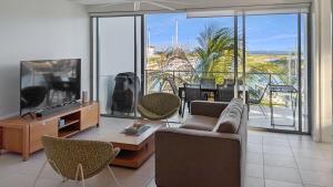 a living room with a couch and a flat screen tv at Blue on Blue Apartment 932 in Nelly Bay