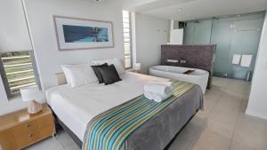 a bedroom with a large bed and a bathroom at Blue on Blue Apartment 932 in Nelly Bay +6 photos