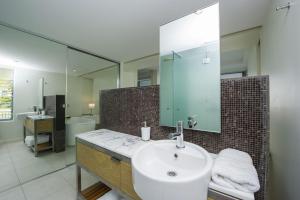 a bathroom with a sink and a mirror at Blue on Blue Apartment 912 in Nelly Bay +17 photos