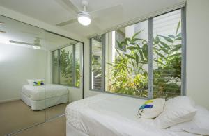 a bedroom with a bed and a large window at Blue on Blue Apartment 912 in Nelly Bay