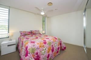 a bedroom with a bed and a ceiling fan at Blue on Blue Apartment 912 in Nelly Bay